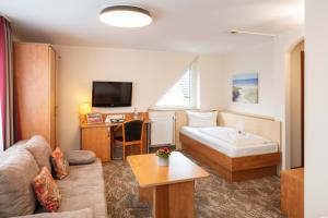 a hotel room with a bed and a desk at Maximilian Hotel & Apartments Weil am Rhein / Basel in Weil am Rhein