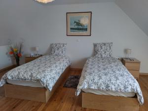 een slaapkamer met 2 bedden en een foto aan de muur bij Verte Vallée in Callac