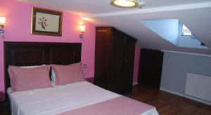 a bedroom with a bed with pink walls at Hotel Tulip House in Istanbul