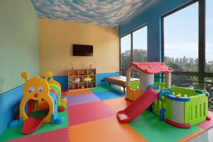 a play room with a slide and a playground at Hotel Aruss Semarang in Semarang