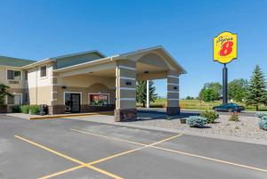 a gas station with a sign in a parking lot at Super 8 by Wyndham Big Timber in Big Timber