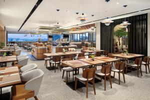 a restaurant with tables and chairs and a bar at Hotel Aruss Semarang in Semarang