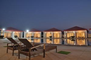 a resort with two chairs on a patio at night at Mannat Resort Paota in Prāgpura
