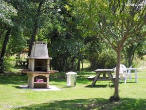a grill and a picnic table in a park at MOBIL-HOME NEUF 6 PERSONNES réservation du samedi au samedi en juillet et août in Urt