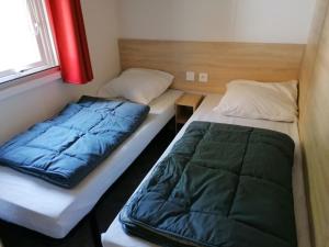a pair of beds in a small room at MOBIL-HOME NEUF 6 PERSONNES réservation du samedi au samedi en juillet et août in Urt