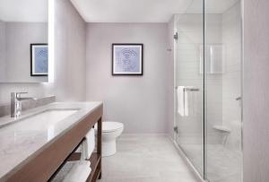 a bathroom with a toilet and a glass shower at Hyatt Place Asheville Airport in Arden