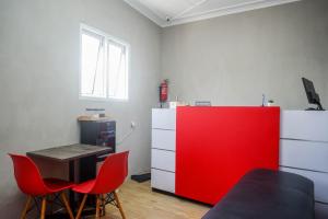 a room with a red cabinet and a table and chairs at RedDoorz @ Jalan Raya Baturaden 2 in Rempawah