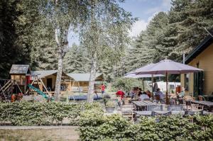 Un groupe de personnes assises à une table avec un parapluie dans l'établissement Camping Siesta, à Lille