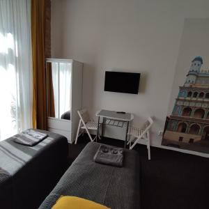 um quarto com uma cama, uma mesa e uma televisão em Rybaki 6A em Poznań