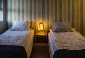 sypialnia z 2 łóżkami i lampką na stole w obiekcie On the Edge of a Crater w mieście Micpe Ramon