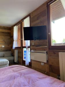 a bedroom with a bed and a flat screen tv at Incantevole appartamento stile chalet Breuil Cervinia in Breuil-Cervinia