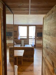 a room with a bed and a table and a window at Incantevole appartamento stile chalet Breuil Cervinia in Breuil-Cervinia