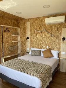 ein Schlafzimmer mit einem Bett und einer Steinmauer in der Unterkunft O REFUXIO DOS CEBREIROS in Mazaricos