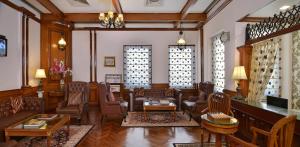 a living room with chairs and tables and windows at Noor-Us-Sabah Palace in Bhopal