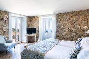 ein Schlafzimmer mit einem großen Bett und einer Steinmauer in der Unterkunft CASA SANTA MARIA in Santa-Reparata-di-Balagna