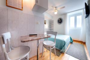 Zimmer mit einem Tisch, 2 Stühlen und einem Bett in der Unterkunft Apartments by the sea Komiza, Vis - 9703 in Komiža