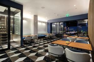 a restaurant with tables and chairs on a checkered floor at Hotel Aruss Semarang in Semarang