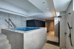 a bathroom with a tub with a shower at Hotel Aruss Semarang in Semarang