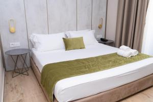 ein Schlafzimmer mit einem großen weißen Bett und einem Tisch in der Unterkunft HOTEL PATIO in Vlorë