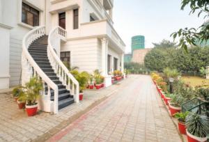 un edificio con scale e piante in vaso su un marciapiede di IIDM ECO RESORT a Lucknow