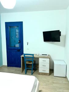 una camera con porta blu e una scrivania con sedia blu di B&B Santorini a Cinisi