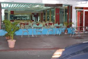 a restaurant with chairs and tables in front of a building at Hypertek Guesthouse in Grand Baie