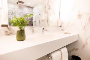 a bathroom with two sinks and a potted plant at Hotel Royal in Vienna