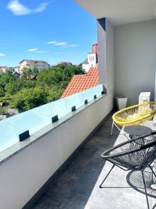 a balcony with a table and chairs and a view at AM Apartments Timișoara Comfort and Free Parking in Timişoara