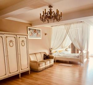 a bedroom with a bed and a couch and a chandelier at Pałac Biedrusko in Poznań +105 photos