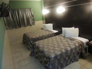 Habitación con 2 camas en una habitación de hotel en Hotel Metropolitano Tampico, en Tampico
