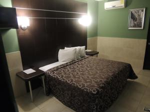 a bedroom with a bed and a lamp at Hotel Metropolitano Tampico in Tampico