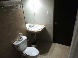 a bathroom with a toilet and a sink at Hotel Metropolitano Tampico in Tampico