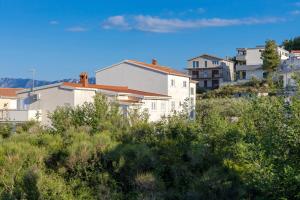 un groupe de maisons sur une colline avec des buissons dans l'établissement Apartments with a parking space Podstrana, Split - 10249, à Podstrana