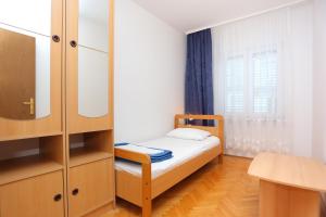 Cette petite chambre comprend un lit et un miroir. dans l'établissement Apartments with a parking space Podstrana, Split - 10249, à Podstrana