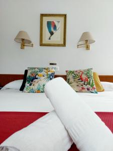 two beds in a hotel room with white sheets at Pension Uxarte in Mondragón