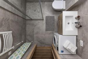 ein kleines Badezimmer mit Waschmaschine und Trockner in der Unterkunft Vanagupes Park Apartments, By Cohost in Palanga + 218 Fotos