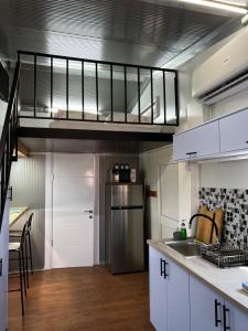 a kitchen with white cabinets and a stainless steel refrigerator at צימראוון בחוות זית המדבר in Sde Boker