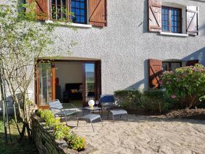 a patio with chairs and a table in front of a house at La Fruitière in Chaudenay