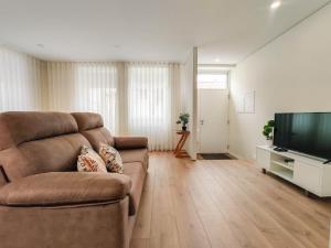ein Wohnzimmer mit einem Sofa und einem Flachbild-TV in der Unterkunft Senhora da Agonia - Apartment in Ribeira in Viana do Castelo