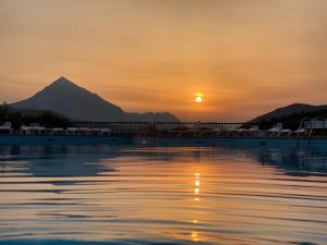 a sunset over a pool with a mountain in the background at Pension Uxarte in Mondragón