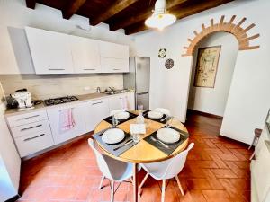 - une cuisine avec une table en bois et des placards blancs dans l'établissement [Art of Bergamo] Luxury & design house, à Bergame