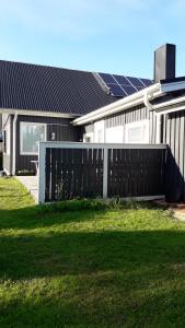 una valla frente a una casa con paneles solares en Majatalo, en Kuopio