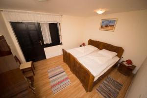 a small bedroom with a bed with a wooden frame at Rooms with a parking space Tordinci, Slavonija - 15159 in Tordinci +10 photos