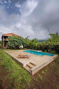a swimming pool in front of a house at SaffronStays Boulevard LogHouse - a wooden chalet amidst nature in Kārli