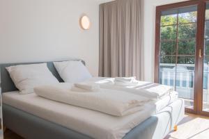 a white bed in a room with a window at Haus Trudi in Walchsee +26 photos
