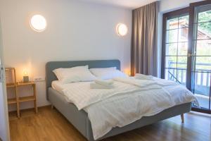 1 dormitorio con 1 cama con sábanas blancas y ventana en Haus Trudi en Walchsee
