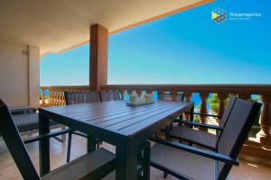 a dining table and chairs on a balcony with the ocean at Apartamento Beach Cala Pi in Cala Pi
