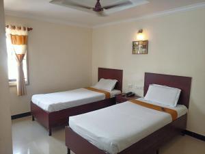 a room with two beds and a window at SKY PARK HOTELS in Tiruppūr
