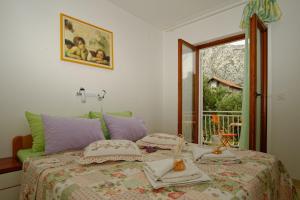 a bedroom with a bed with a table and a window at Apartments with a parking space Orebic, Peljesac - 14834 in Orebić
