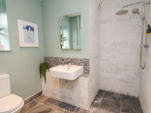 a white bathroom with a sink and a toilet at Ty Ni in New Quay +29 photos